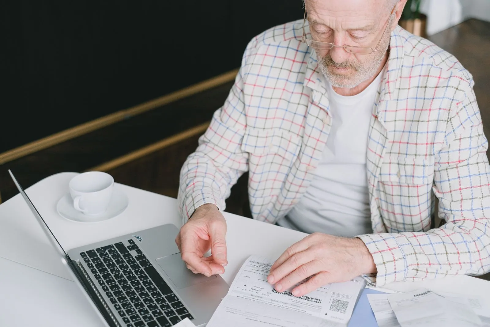 A person reviewing a retirement account statement at a home office desk