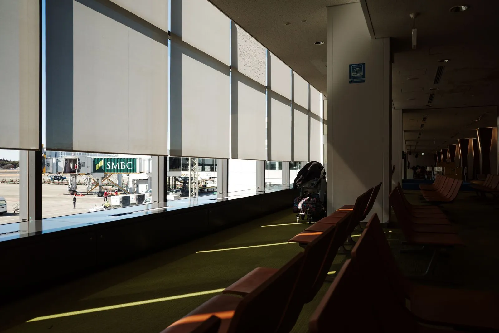 A quiet airport terminal seating area with sunlit chairs