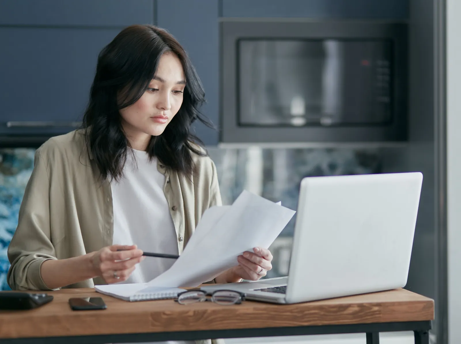 Woman reviewing paperwork at a desk while preparing a written complaint.
