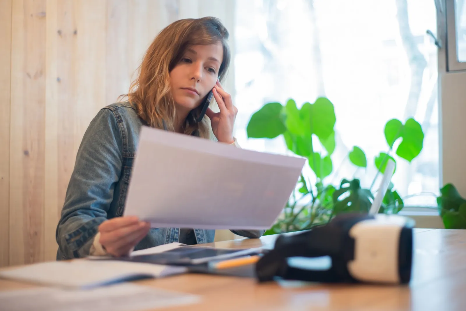 Person at a desk reviewing loan documents by a laptop