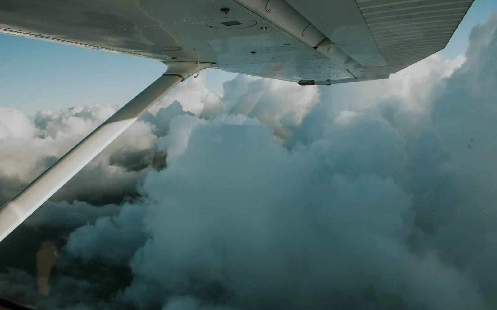 View of an airplane wing above the clouds