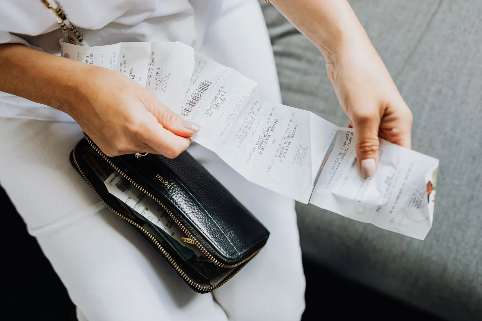 A person reviewing a paper receipt at a coffee shop counter