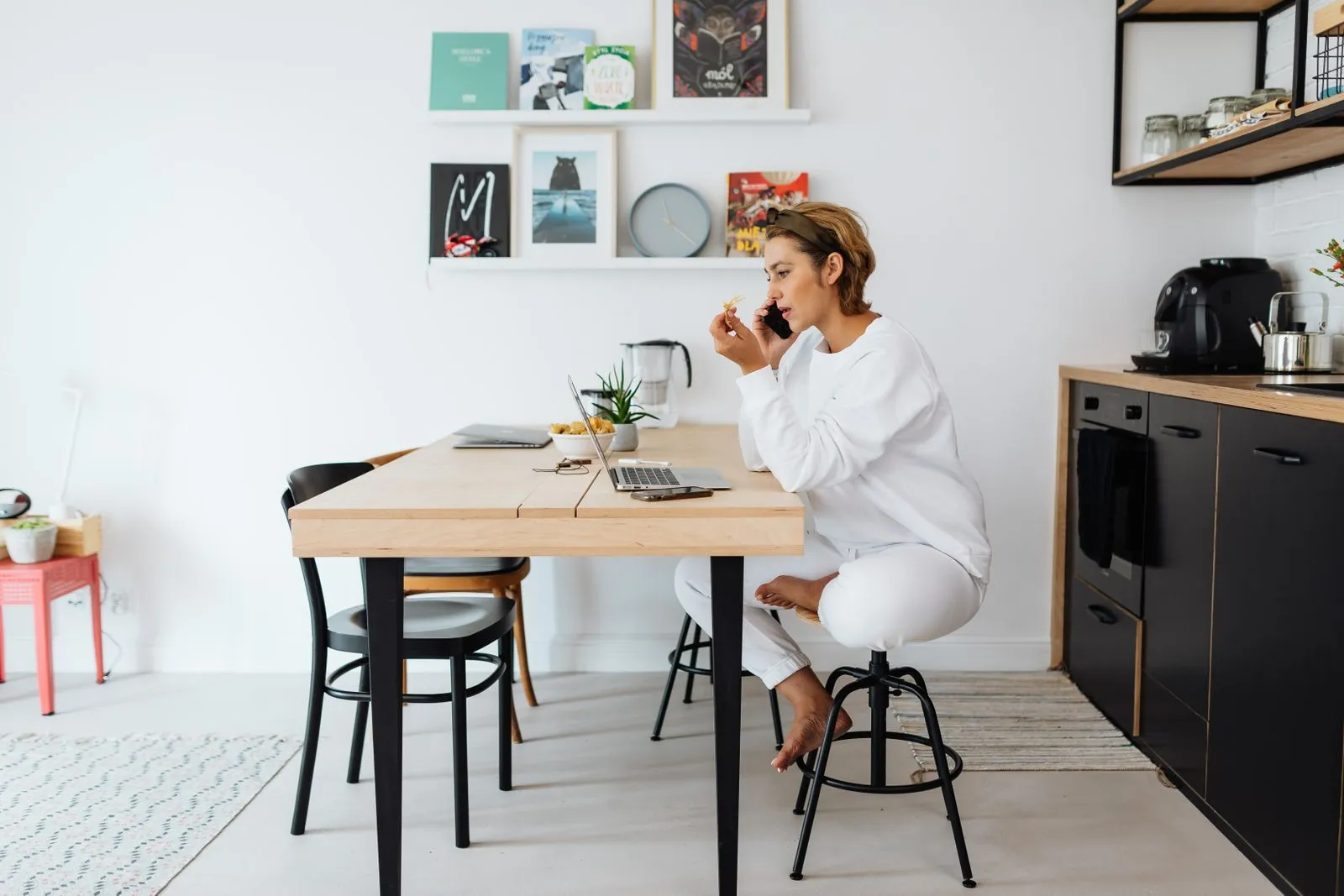 Person on the phone at a kitchen counter with a laptop and a credit card statement in front of them