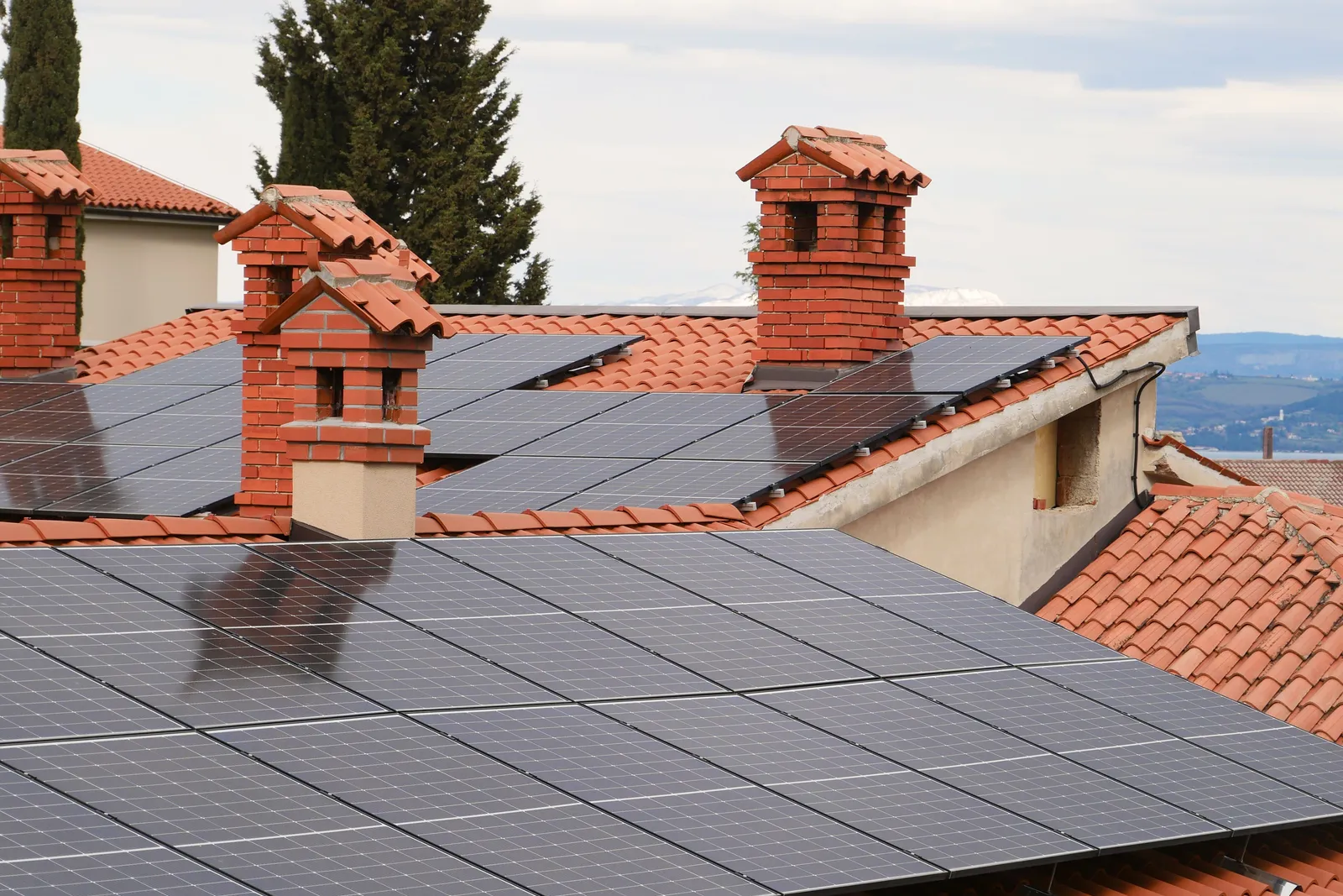 Solar panels mounted on tiled rooftops in a residential neighborhood