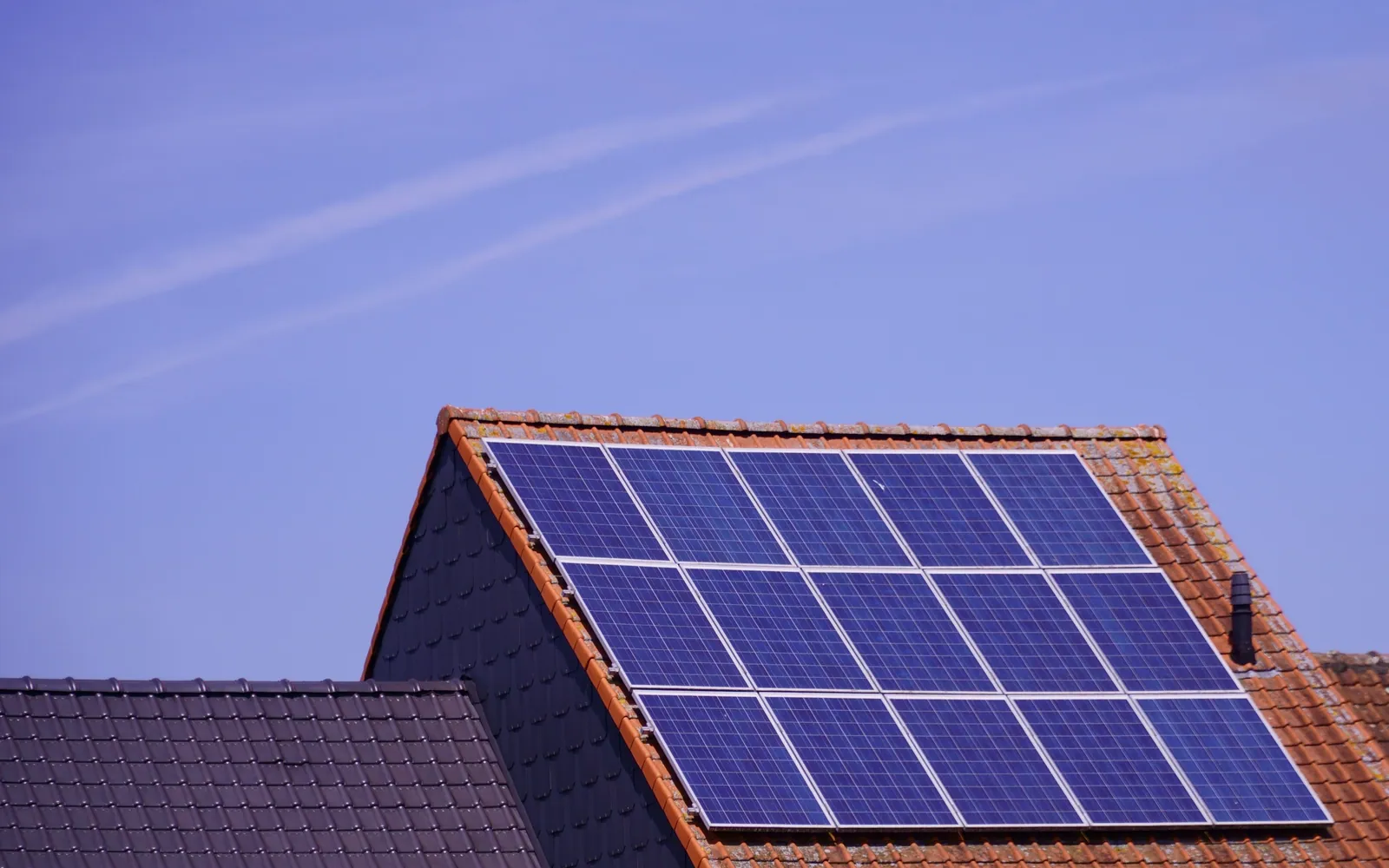 Solar panels on a home roof against a clear sky