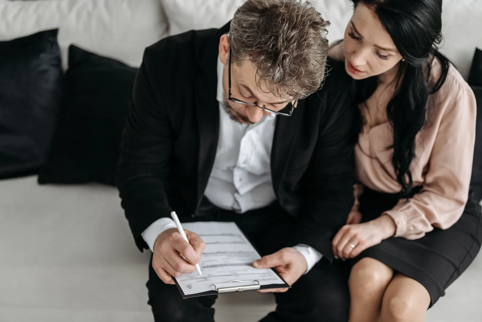 A couple sitting at a table reviewing paperwork together at home