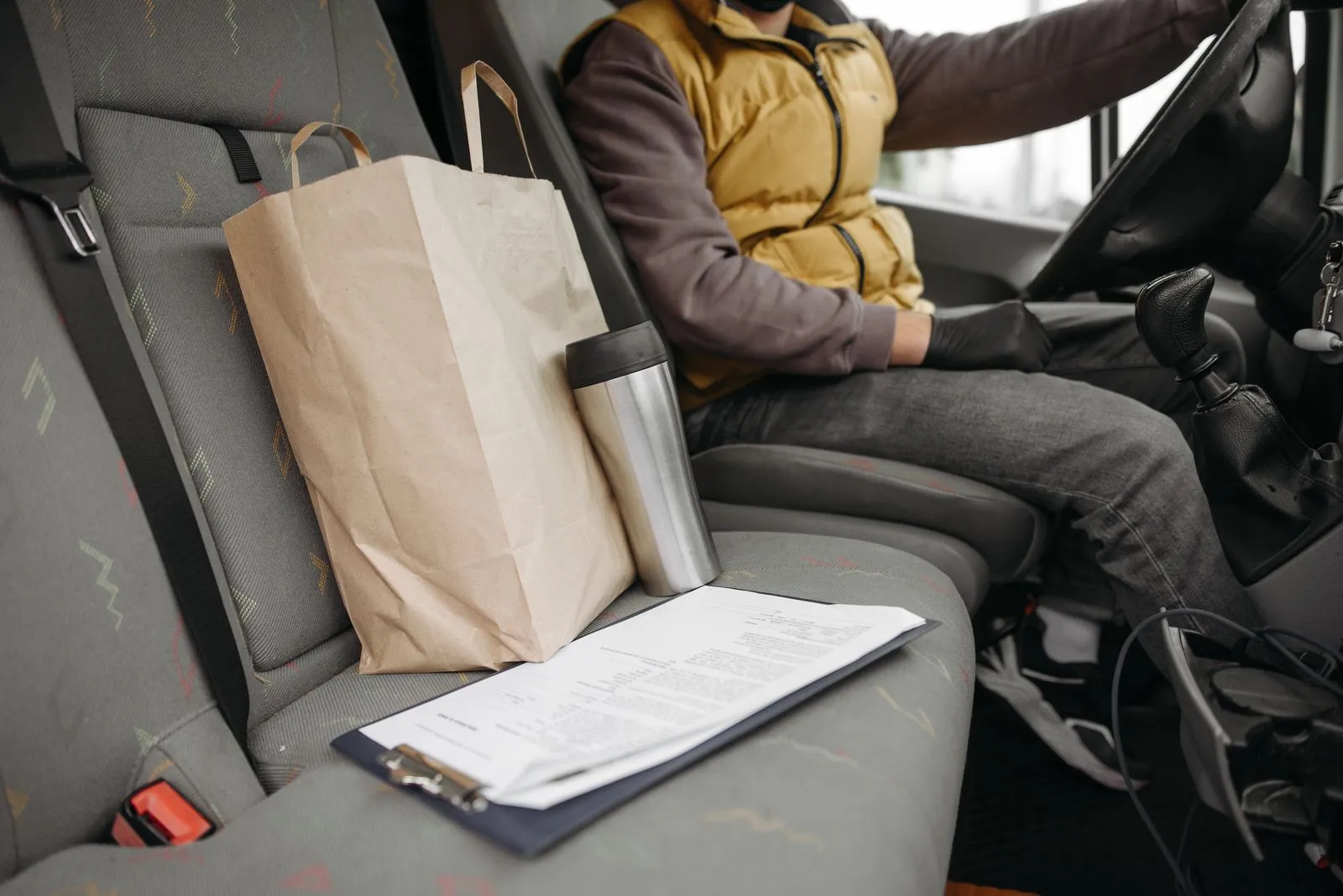 Rideshare or delivery driver in the front seat of a work vehicle