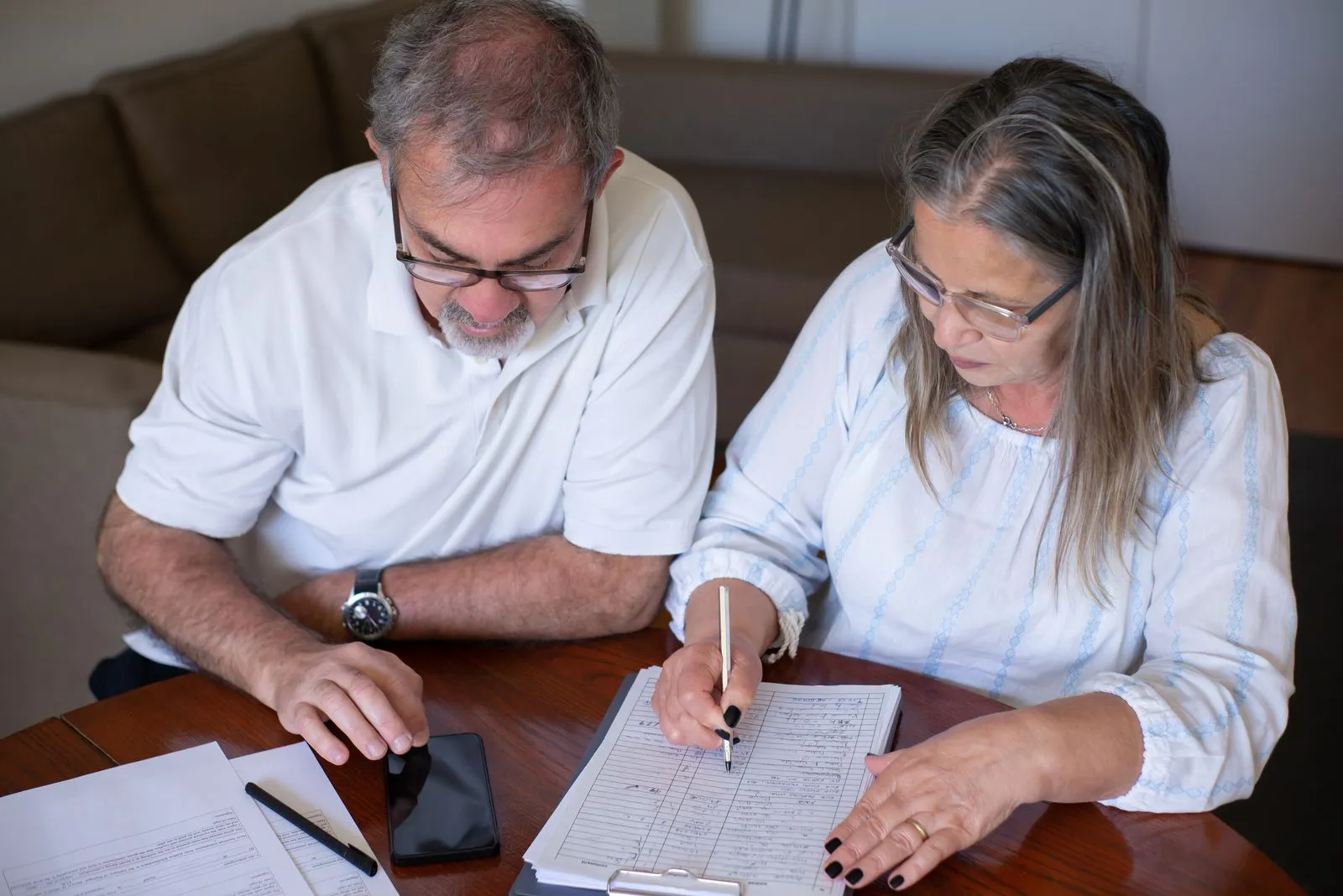 Retired couple reviewing a household budget at the kitchen table