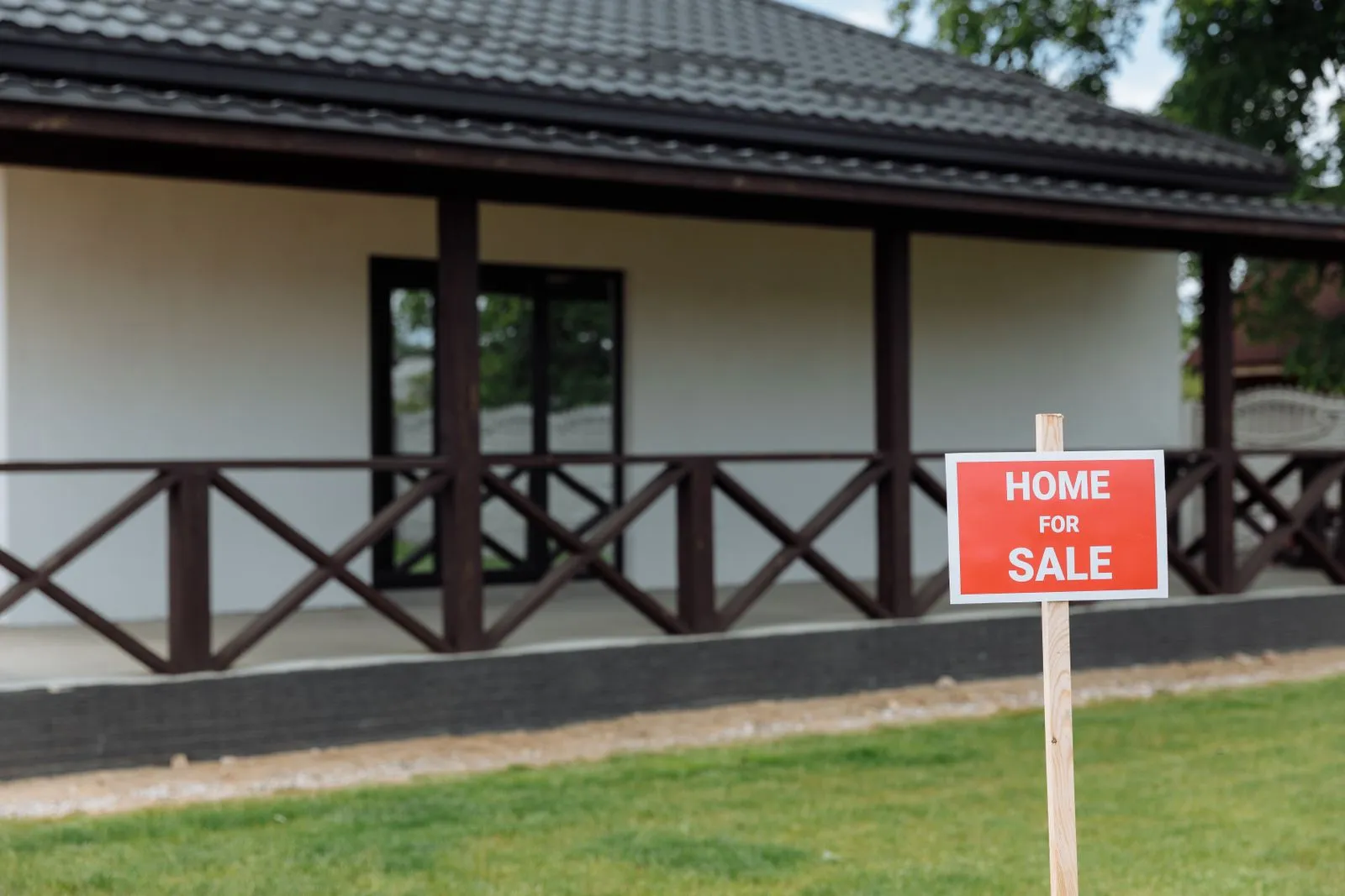 Suburban house with a for-sale sign in the front yard on a quiet street