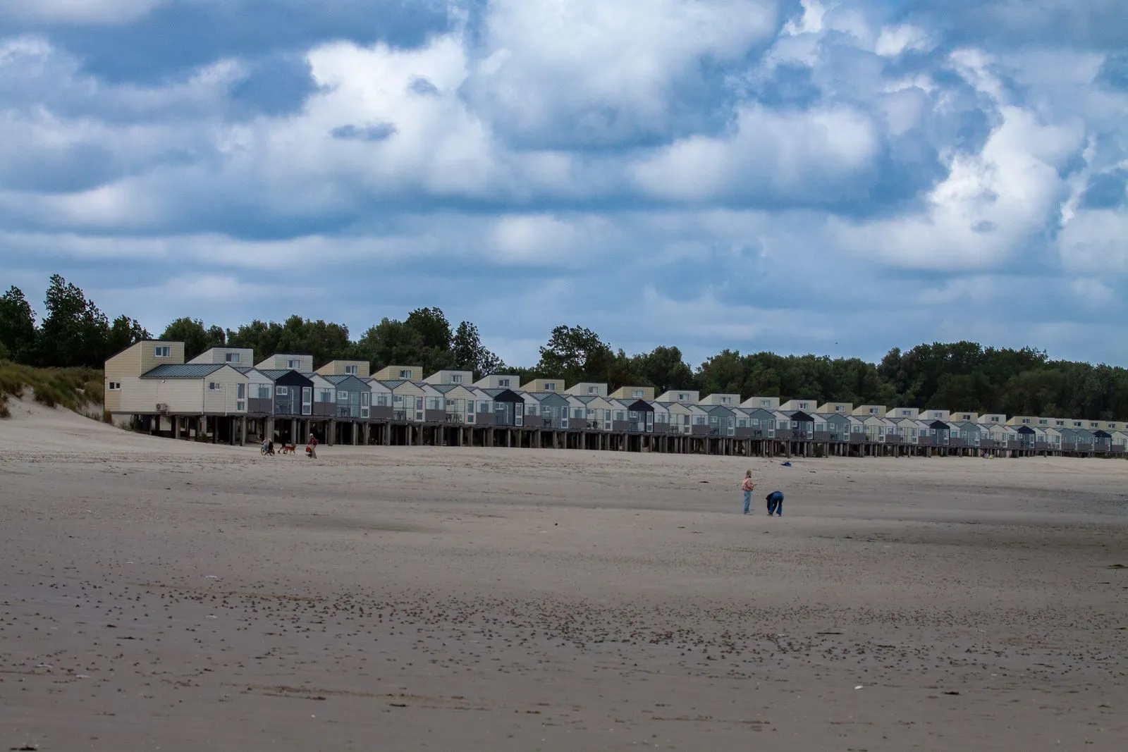 Coastal neighborhood with houses on stilts under a cloudy sky