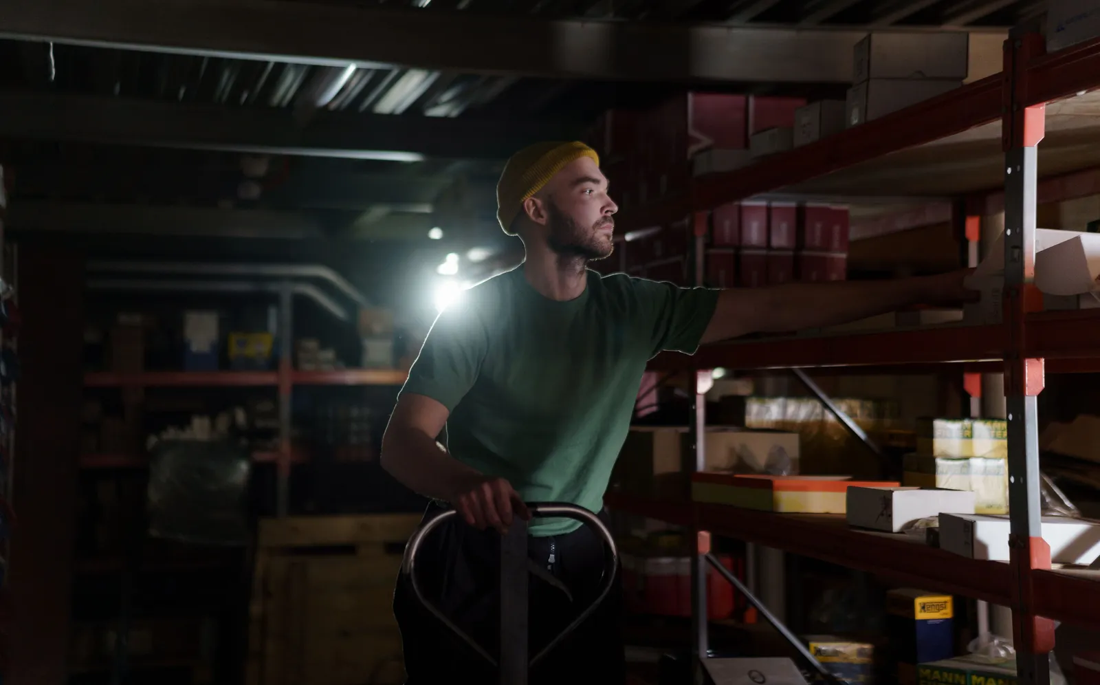 Warehouse worker organizing inventory on metal shelves during a shift