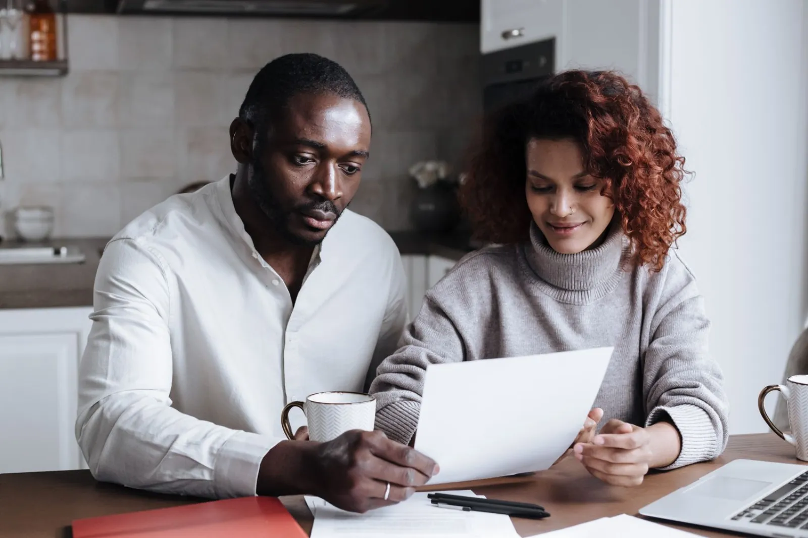 A couple reviewing paperwork together at a kitchen table