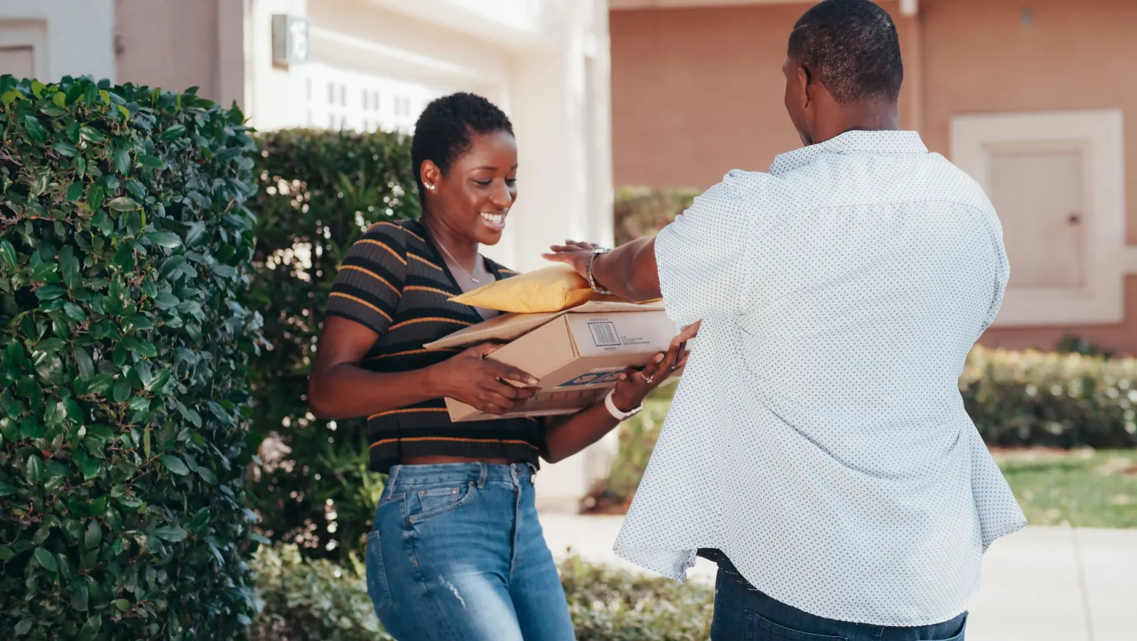 A person reviewing a delivery box and a smartphone on a kitchen counter