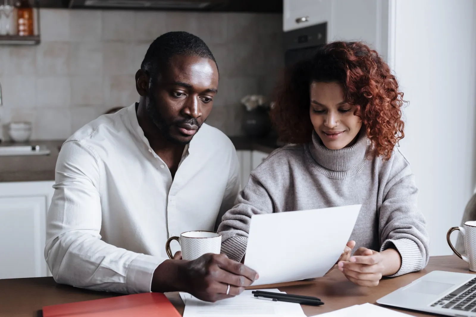 Renter sitting at a kitchen table paying bills on a laptop