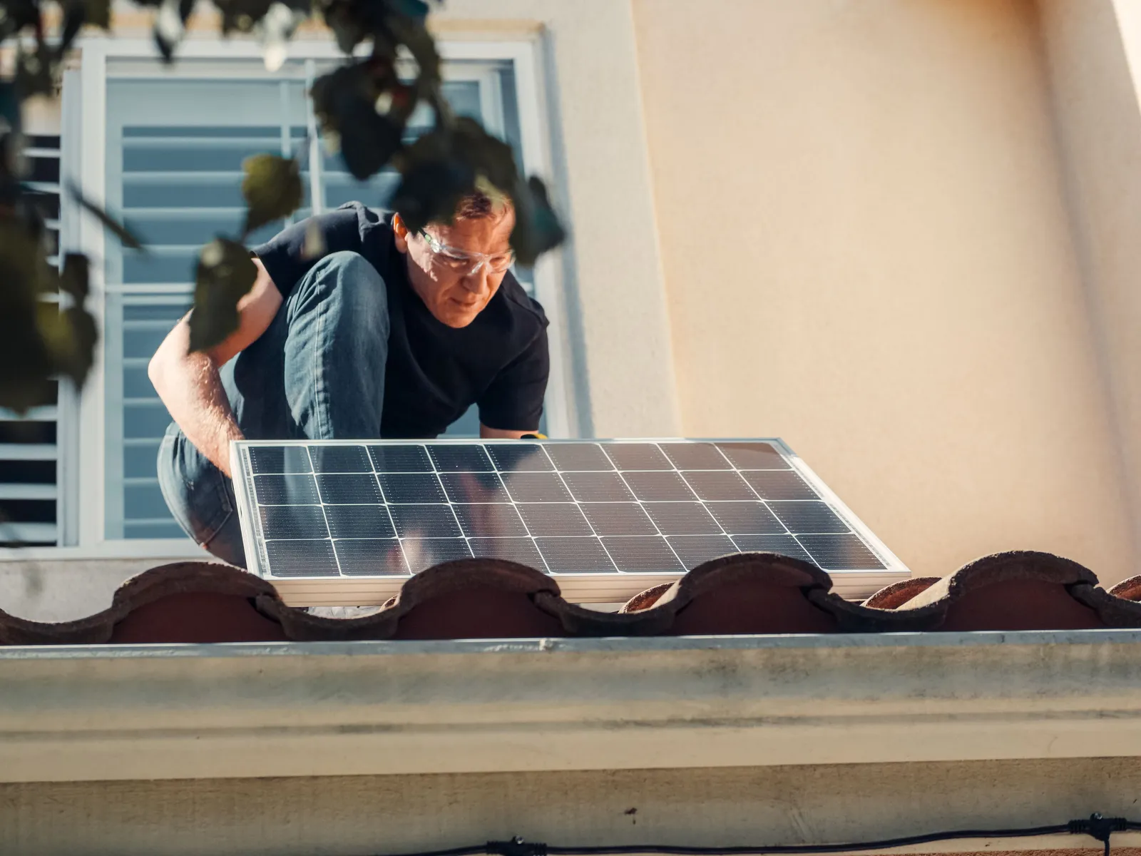 Installer working on rooftop solar panels on a residential home