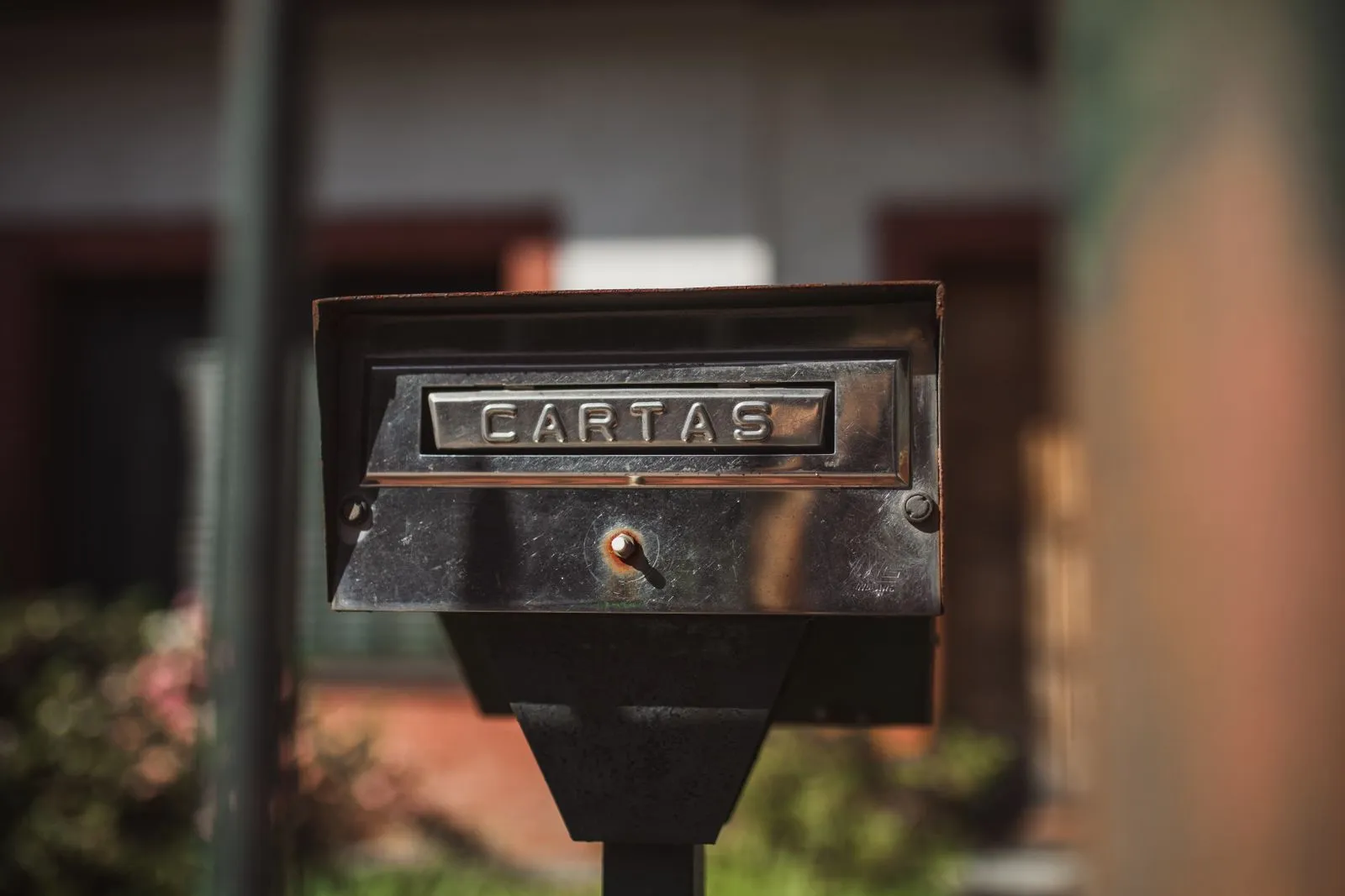 Suburban mailbox at the end of a driveway in front of a home