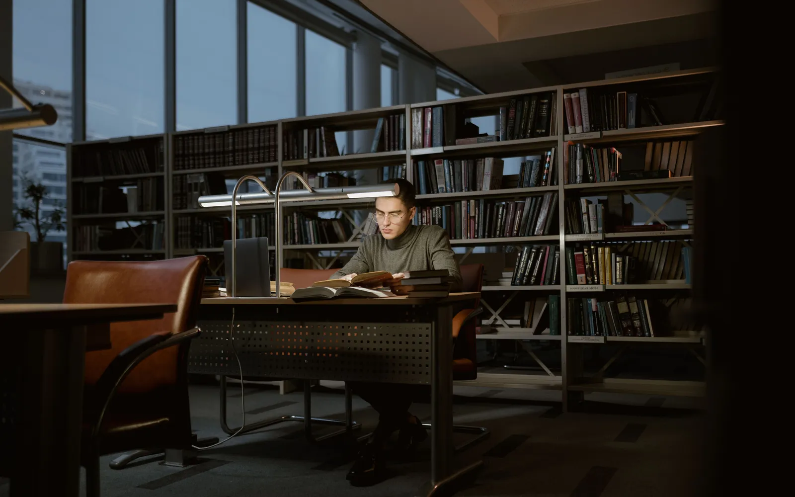 Graduate student reading at a desk in a university library