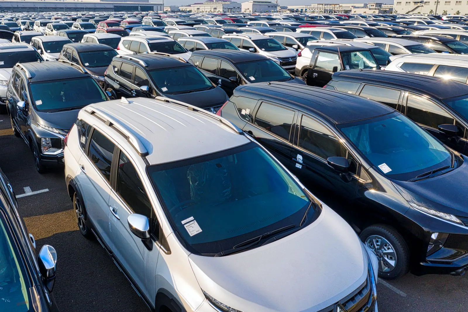 Used car dealership lot with a row of parked sedans on a bright afternoon
