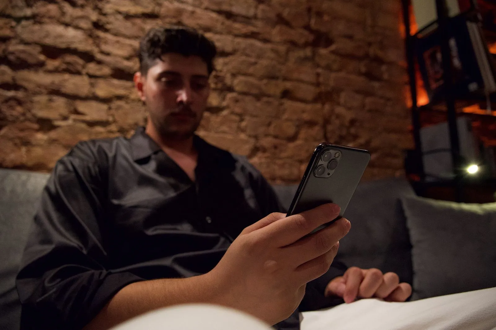 Person using a phone dating app late at night on a couch