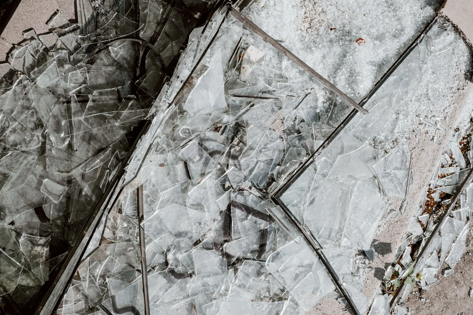 Shattered safety glass scattered across concrete pavement