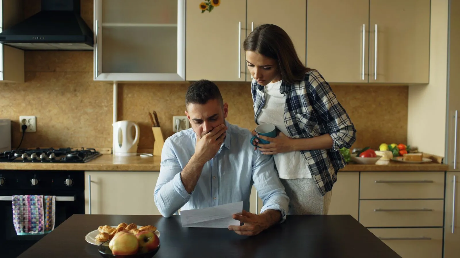 Person opening a hospital bill at a desk with a coffee cup