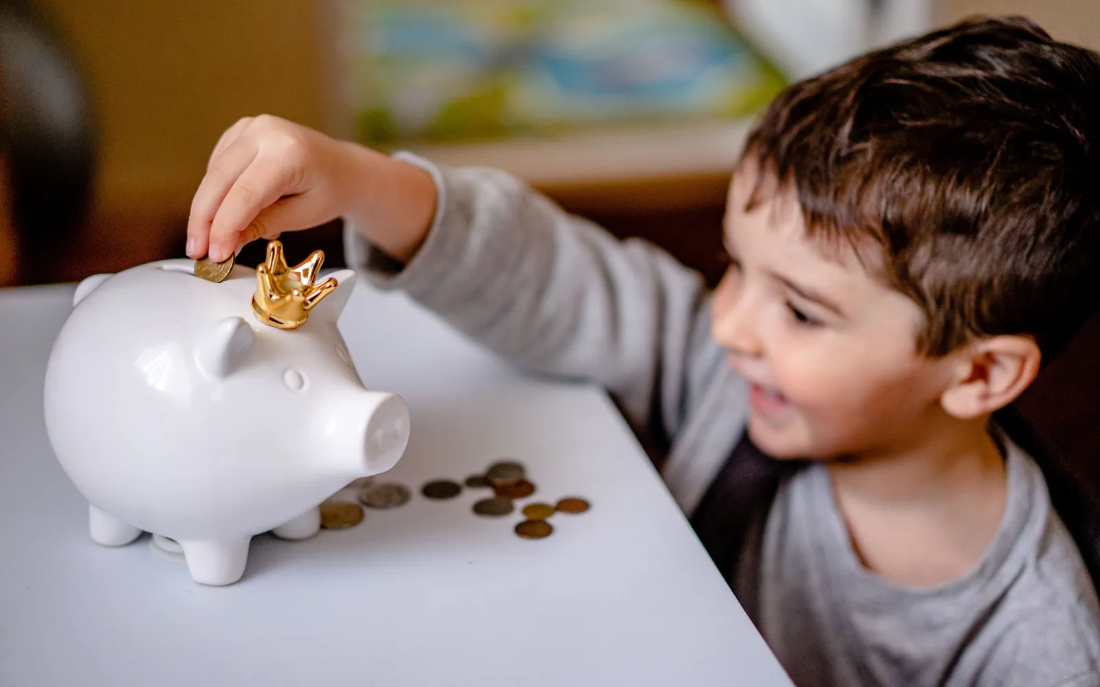 Child putting a coin into a piggy bank