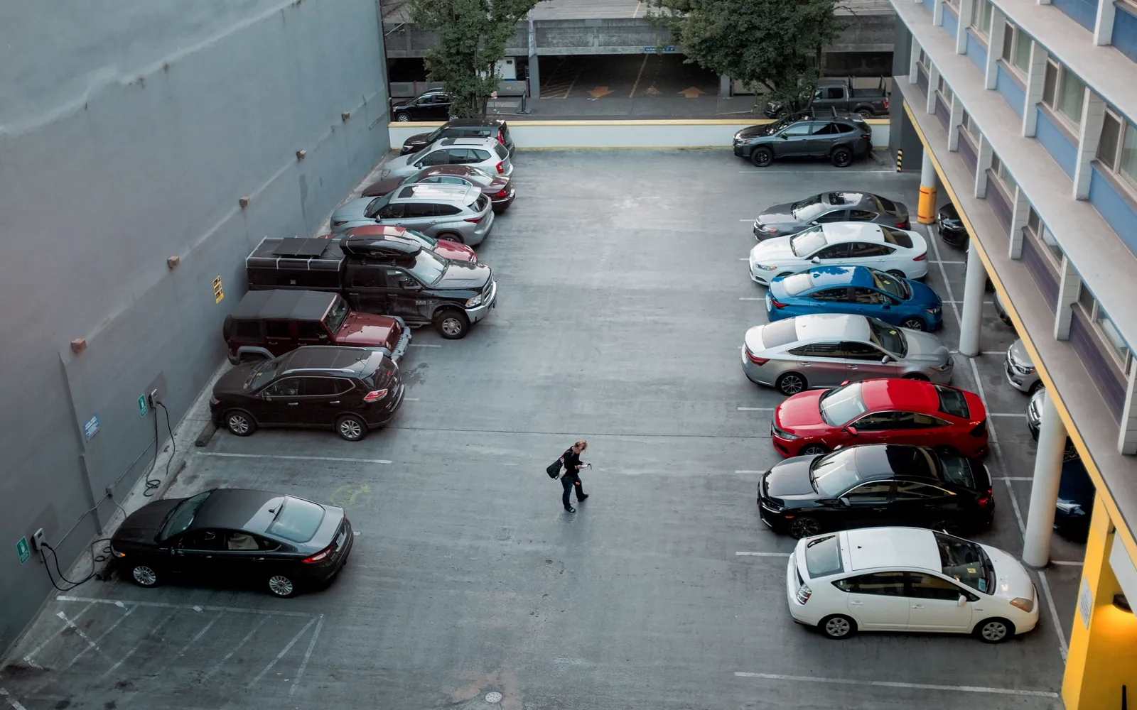 Person standing beside a parked car