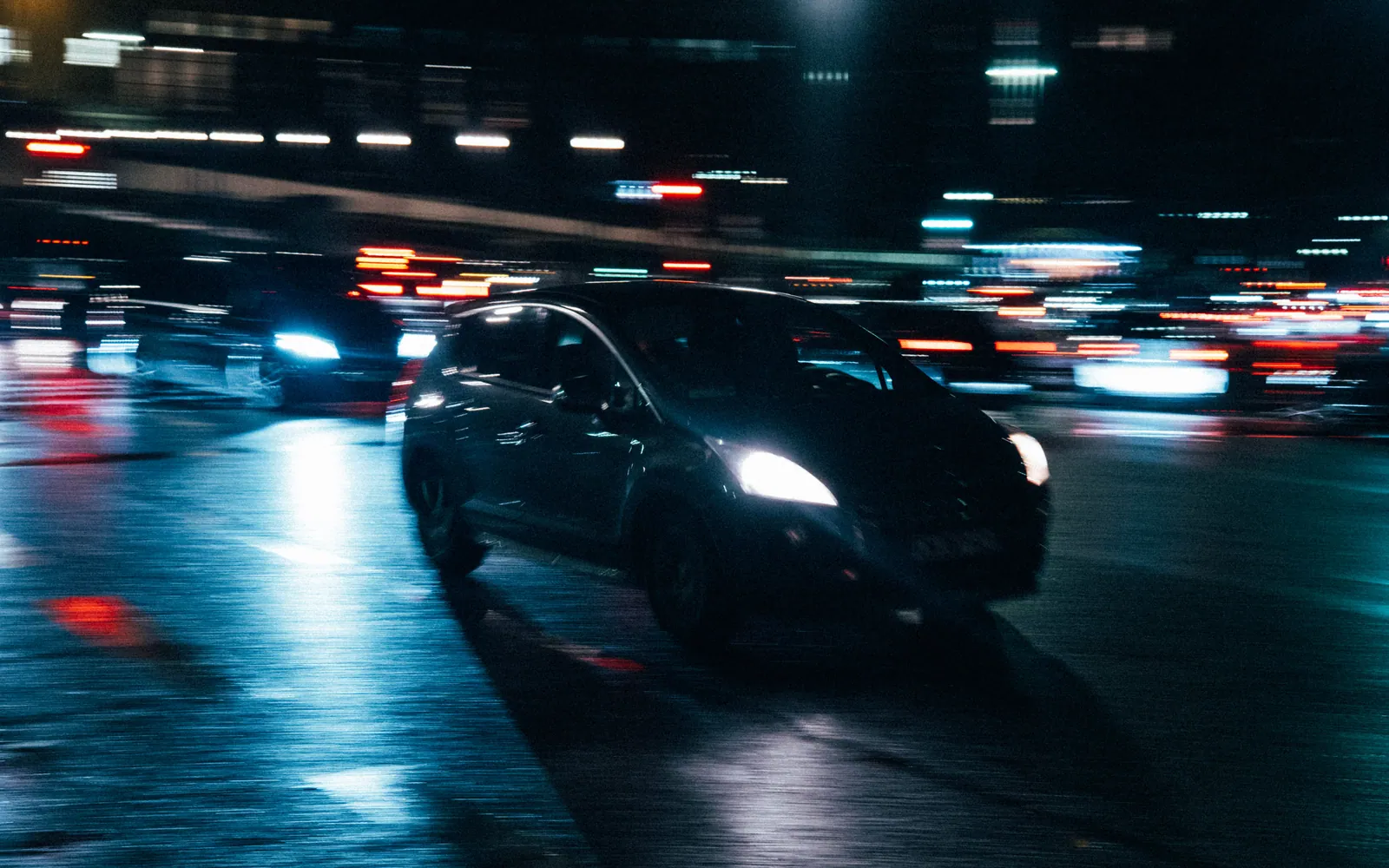 Car driving through the city at night