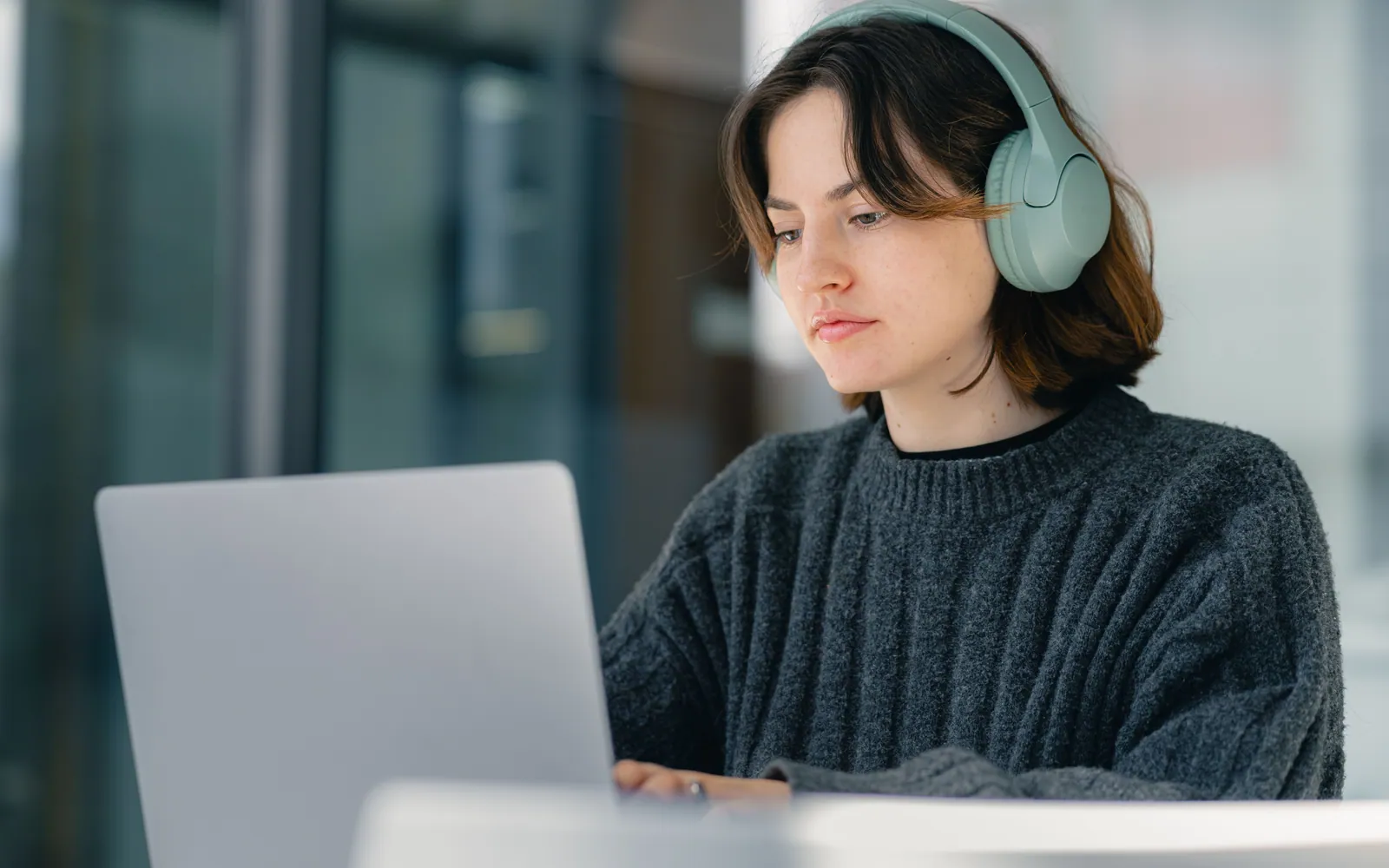 Adult studying online with a laptop and headphones