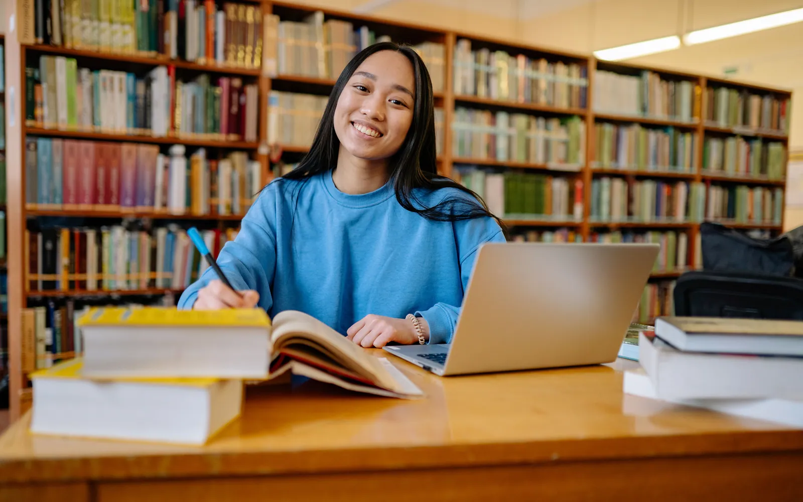 Student studying with a laptop and books