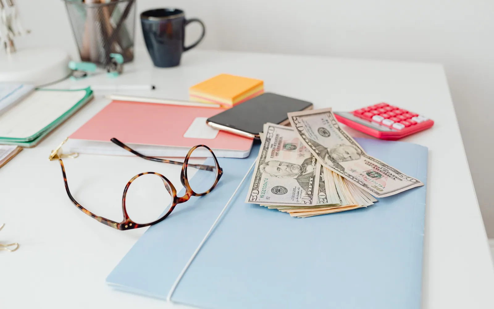 Stack of bills and a calculator on a desk