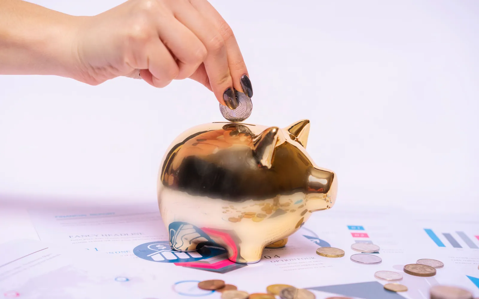Hand putting a coin into a piggy bank