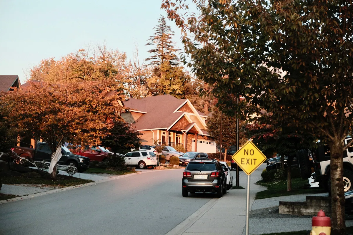 Family loading car in suburban driveway