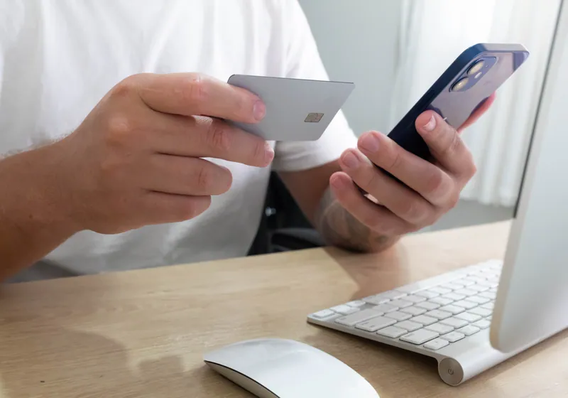 Person holding credit cards and phone