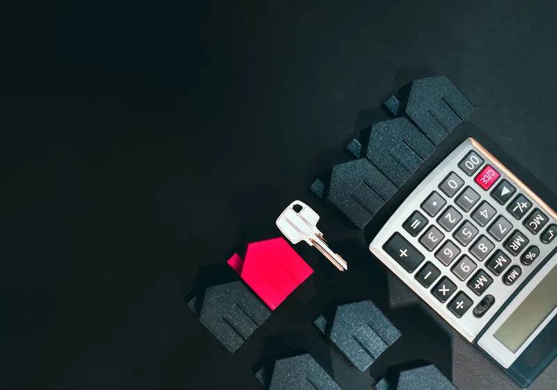 Calculator and house keys on a desk