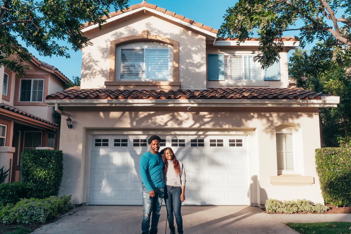 Couple in front of new home
